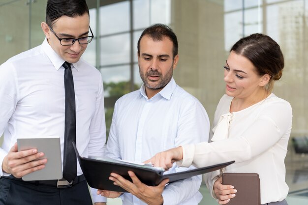 Business woman pointing at document in hands of coworker