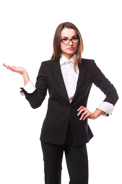 Business woman points at something in her back. Isolated on white wall