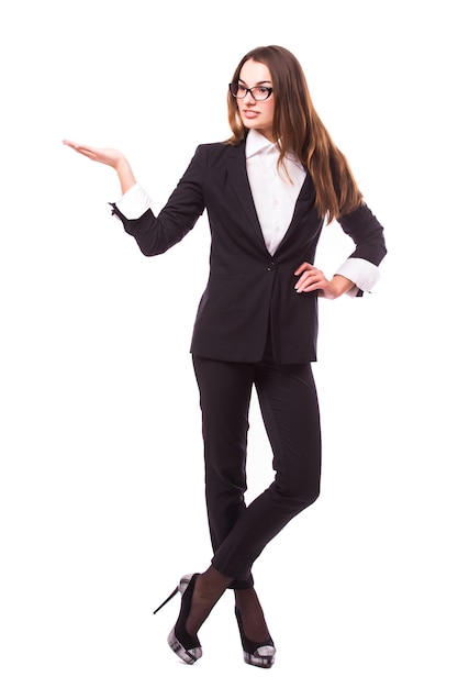 Business woman points at something in her back. Isolated on white wall