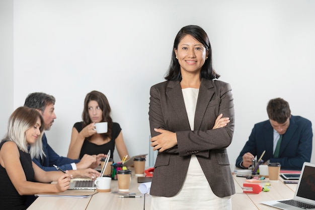 Foto gratuita donna di affari che posa in vestito all'ufficio