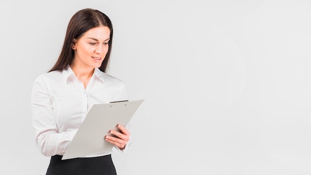 Free photo business woman in shirt writing on clipboard