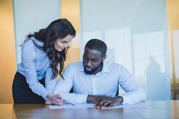 Business woman showing something to man