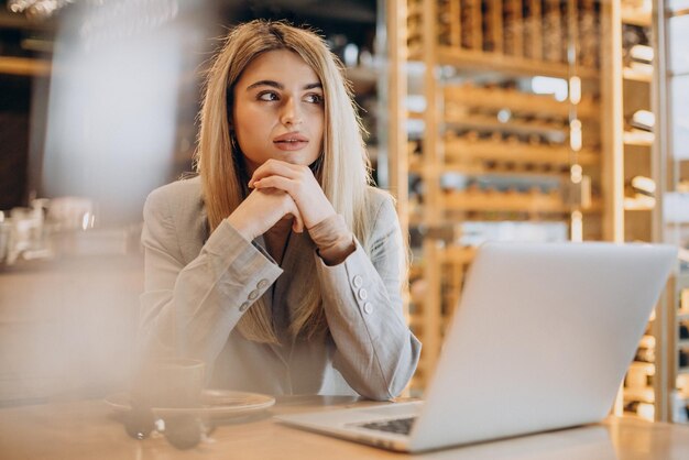 Business woman sitting in cafe and working online