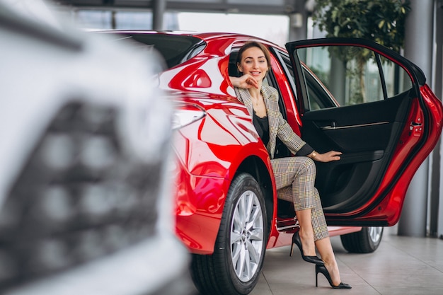 Business woman sitting in a red car