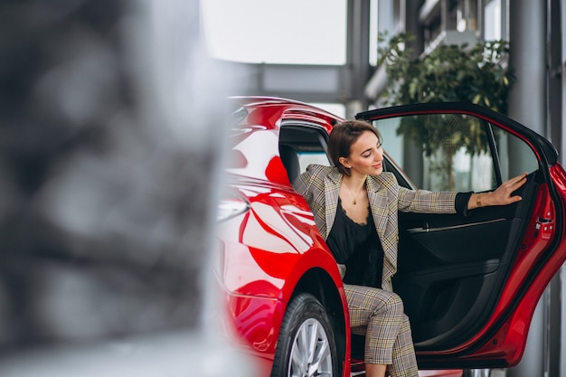 Business woman sitting in a red car