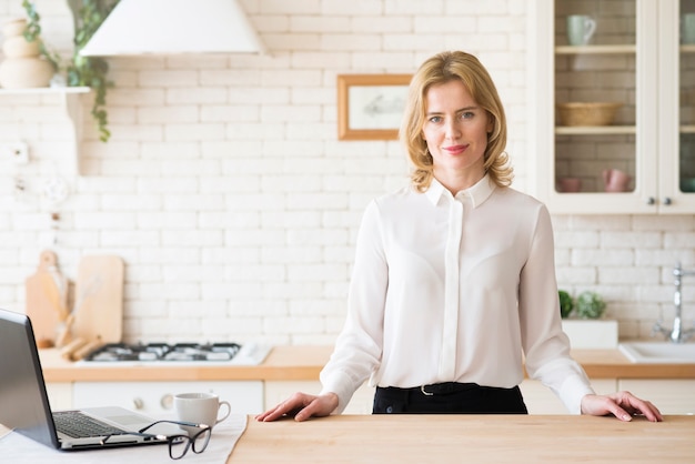 Business woman standing at table with laptop 