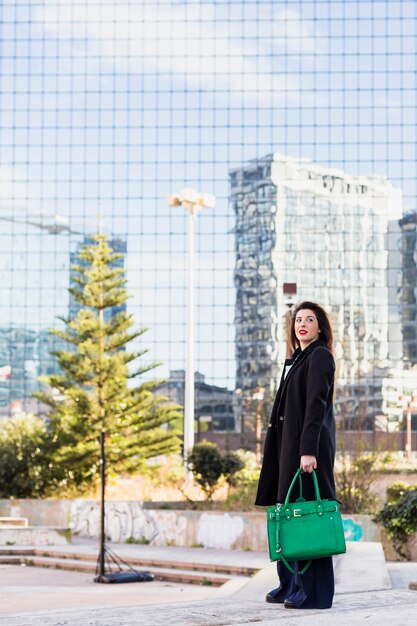 Business woman standing with bag outside