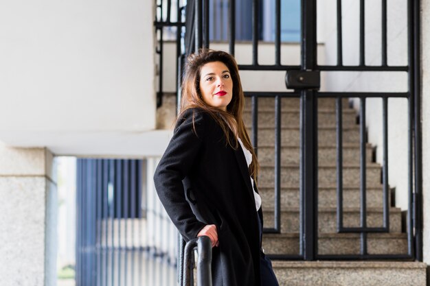 Business woman in suit leaning on railing 