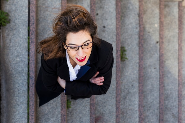 Business woman in suit standing on stairs outside 