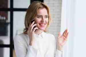 Free photo business woman talking on phone and smiling