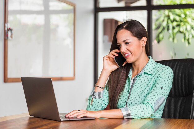 Business woman talking at the phone and smiling