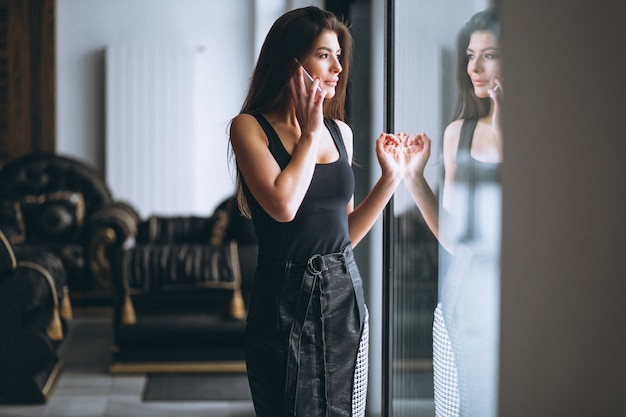 Business woman talking on phone standing by the window