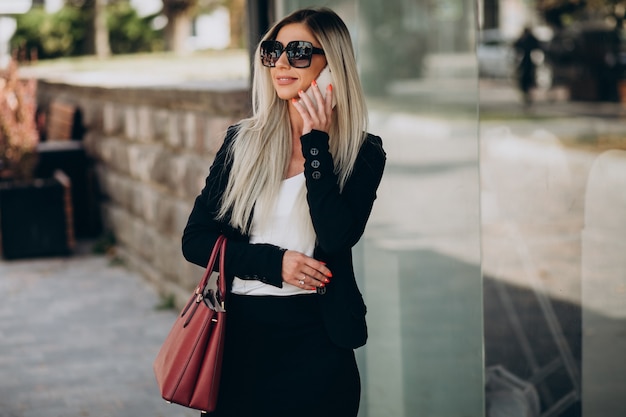 Business woman talking on the phone in the street