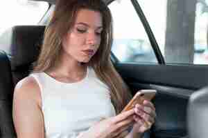 Free photo business woman using the smartphone in the car