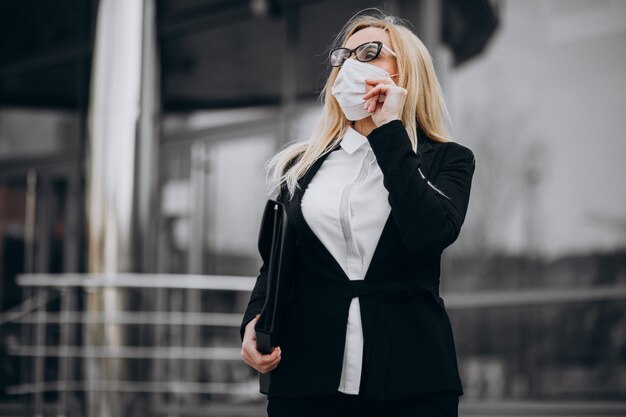 Бизнес женщина носить маску за пределами бизнес-центра