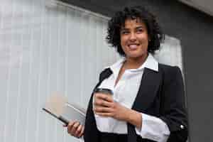 Free photo business woman with coffee cup side view