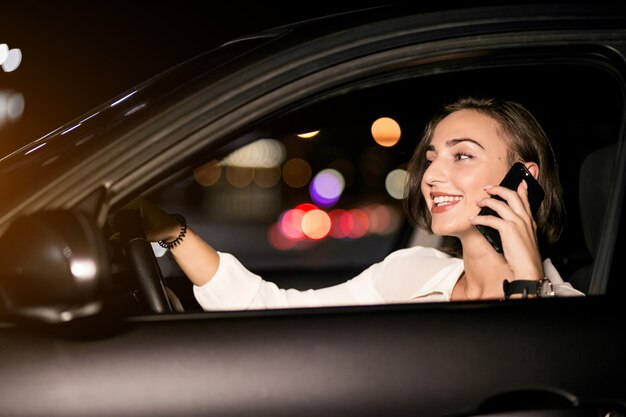 Business woman with the phone in car