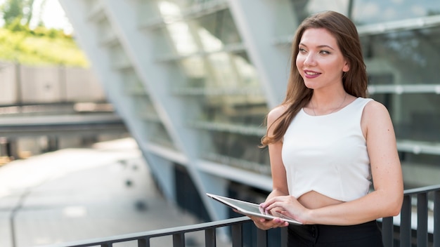 Business woman with a tablet in the street