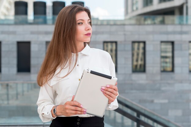 Business woman with a tablet in the street