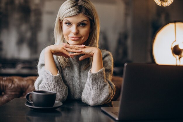 Бесплатное фото Деловая женщина, работающая на компьютере в кафе