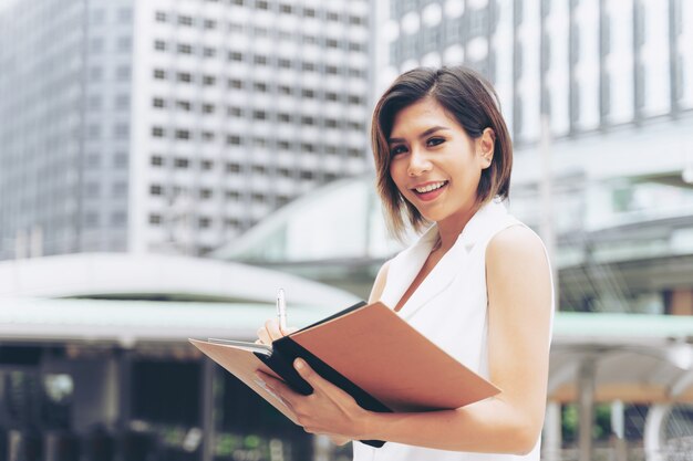 Business woman writing on book 