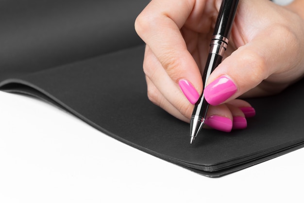 Руки бизнес-леди работая пишущ тетрадь