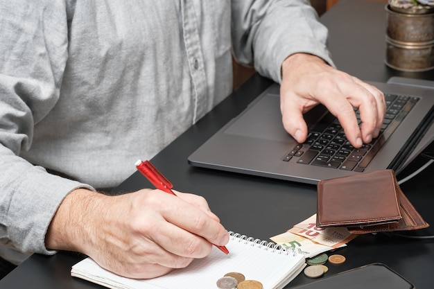 Free photo businessman or accountant holding pen working at desk using a laptop to calculate financial report