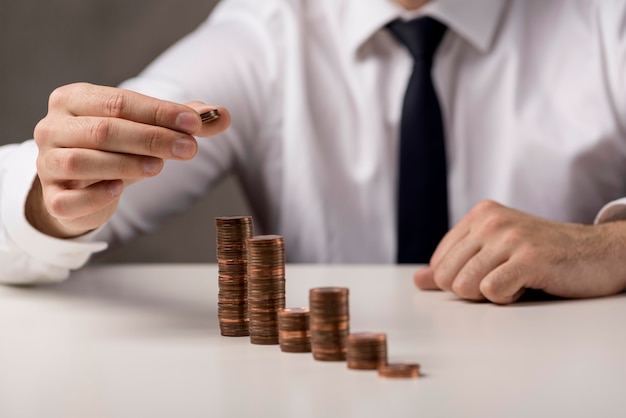 Businessman adding coin to stack