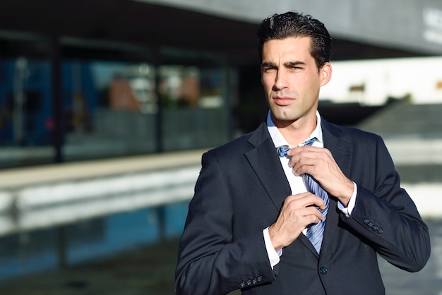  businessman adjusting his tie