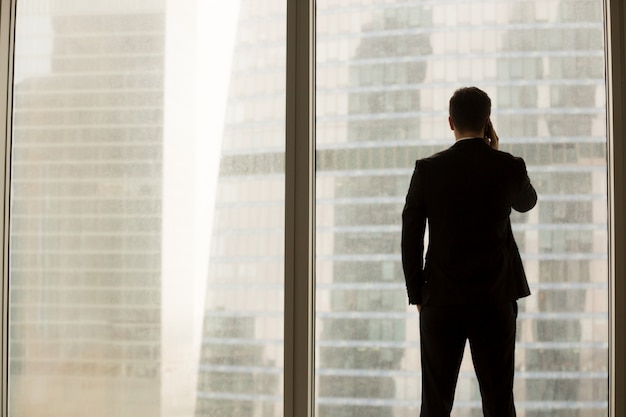 Businessman answering confidential call in office