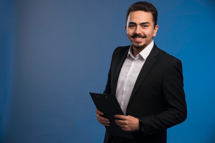 Free Photo businessman in black suit holding the tasklist.