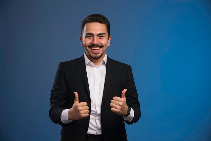 Free Photo businessman in black suit makes thumb up sign.