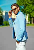 Free photo businessman in blue suit wearing sunglasses in the street