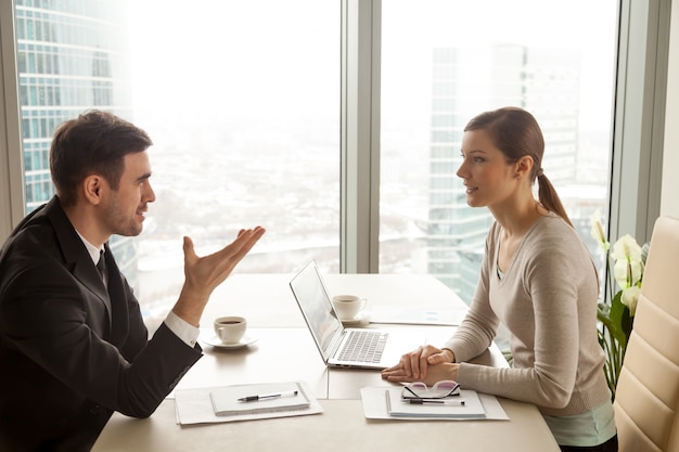 Businessman and businesswoman discussing work at office desk