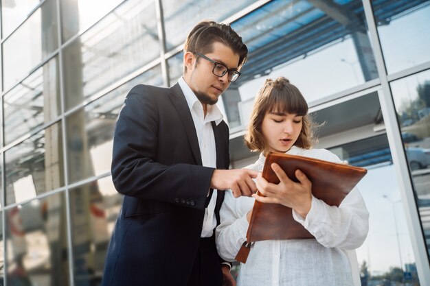 Businessman and businesswoman look at important papers