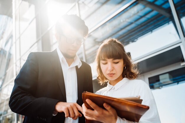 Businessman and businesswoman look at important papers