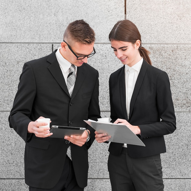 Businessman and businesswoman looking at clipboard