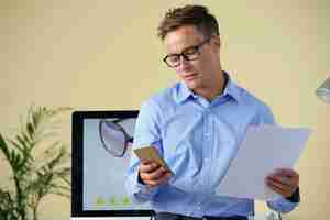 Free photo businessman checking phone