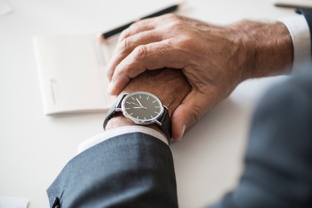 Foto gratuita uomo d'affari che controlla orologio a disposizione