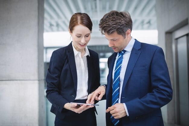 Businessman and colleague discussing over digital tablet