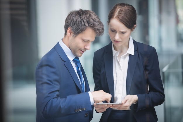 Businessman and colleague discussing over digital tablet