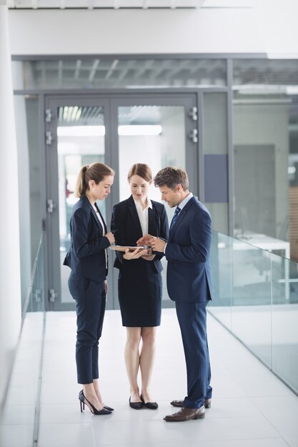 Businessman and colleague discussing over digital tablet