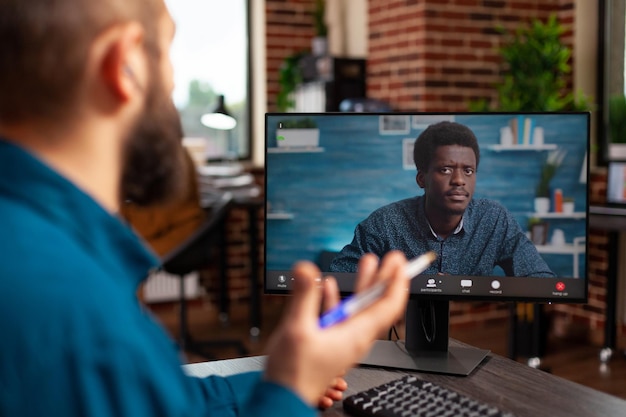 Businessman discussing marketing strategy with remote employee during online videocall meeting conference using computer. Manager working at company presentation in startup office. Teleconference call