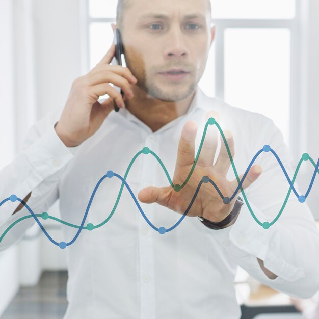 Businessman doing phone call and looking at charts