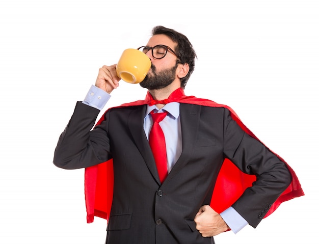 Businessman dressed like superhero drinking coffee