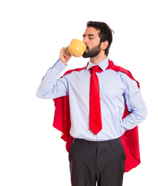 Businessman dressed like superhero drinking coffee