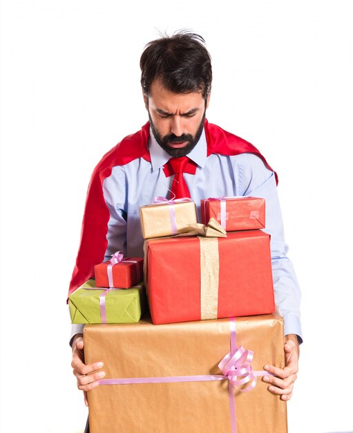 Businessman dressed like superhero holding gifts