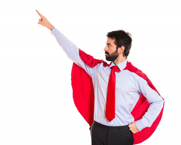 Businessman dressed like superhero pointing to the lateral