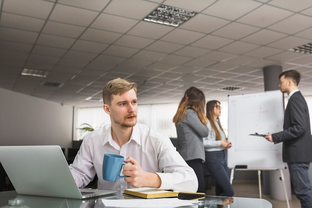 Businessman drinking coffee in office