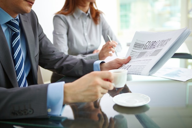 Businessman drinking coffee and reading the newspaper